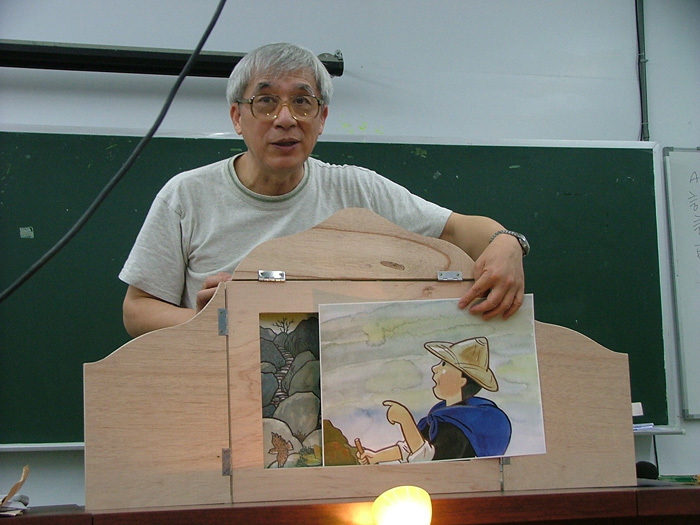 曹俊彥說演自製畫片《加油樹》的故事，示範木箱式的紙芝居如何抽換畫片